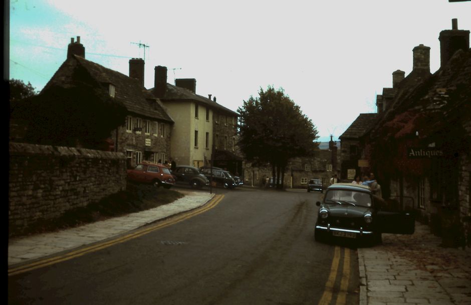 A quaint street in a historic town featuring vintage buildings and a classic car, evoking nostalgia.