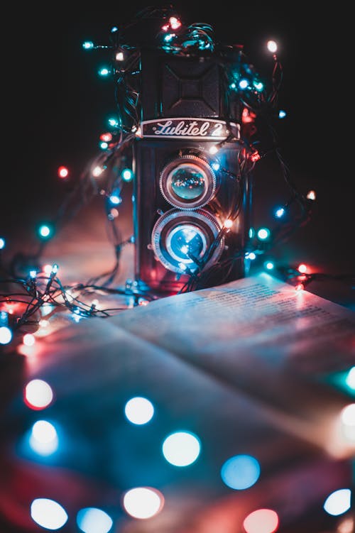 Free Turned-on String Lights Surrounded the Dual-lens Reflex Camera Stock Photo