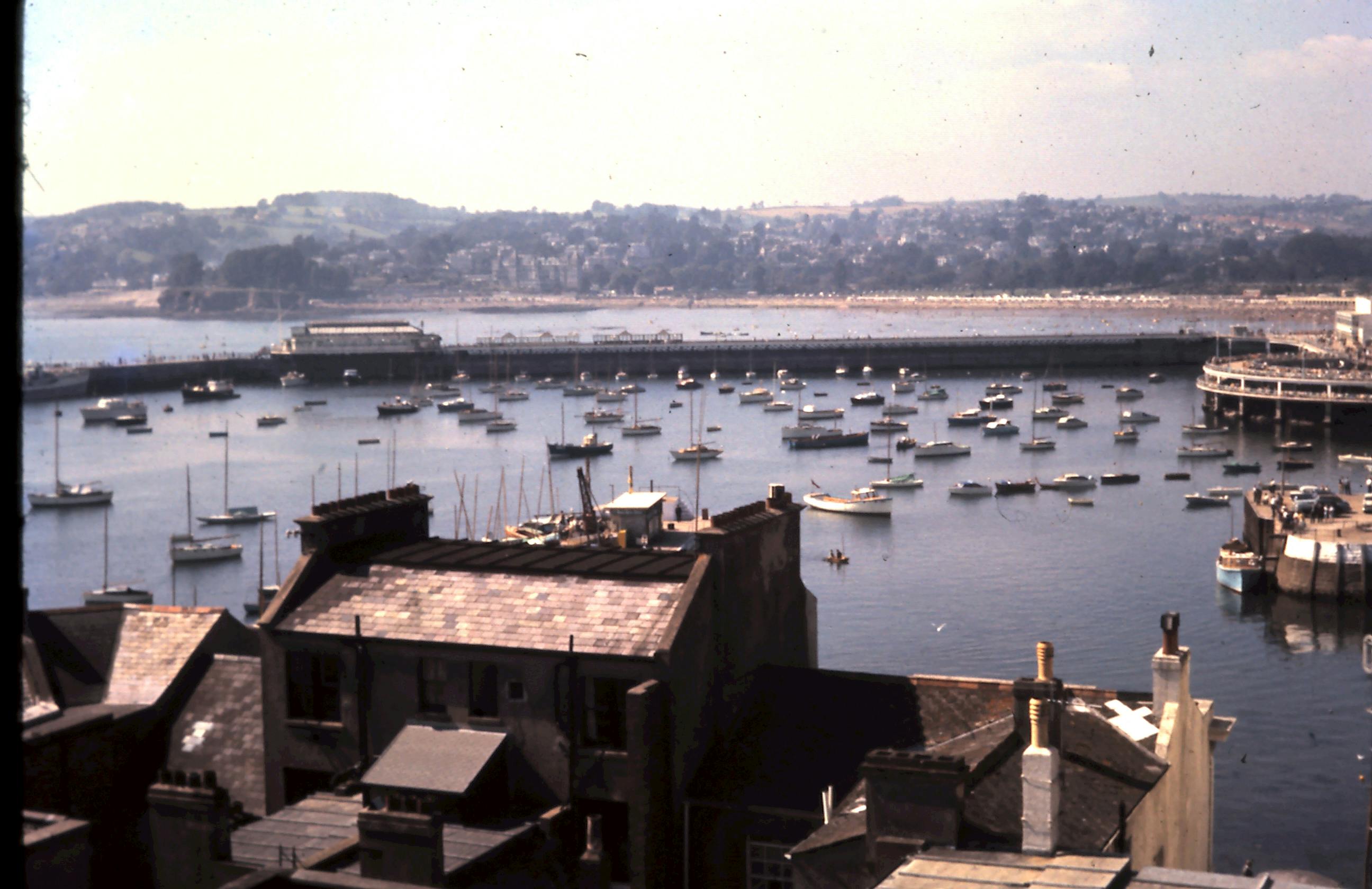 A scenic aerial view of Torquay harbor, filled with boats on a sunny day in England.