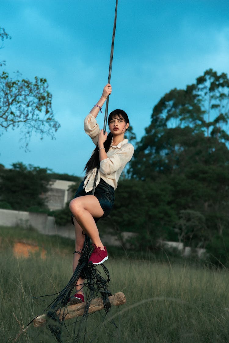 Graceful Woman Swinging On Rope In Countryside