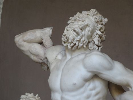 Close-up of an ancient marble sculpture displaying dramatic expression and intricate carving.