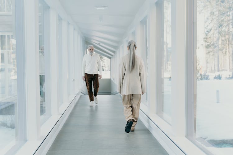 A Man And A Woman Walking On The Hallway