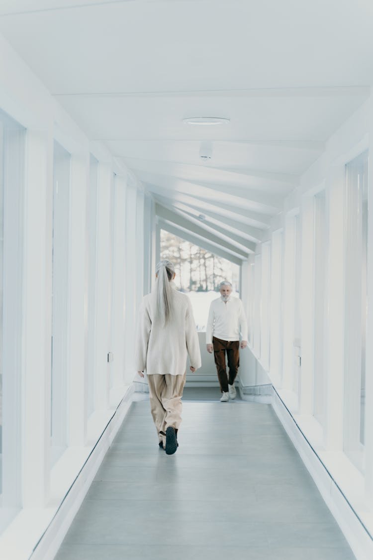 A Man And A Woman Walking On The Hallway