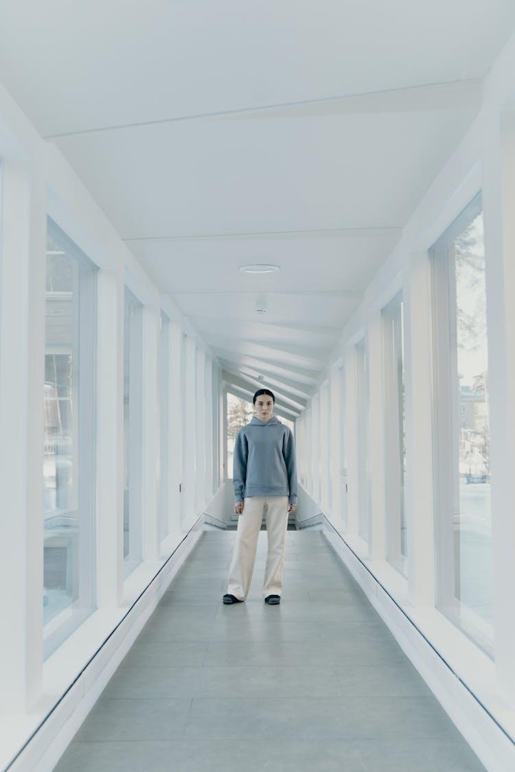 Person In Blue Hoodie Sweater Standing On Hallway