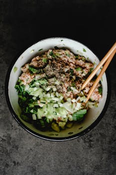 Close-up of ground pork mixed with vegetables and spices in a bowl, ready for cooking.