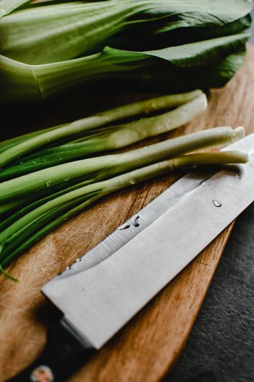 Free Bok Choy and Onion Leaks on a Chopping Board Stock Photo