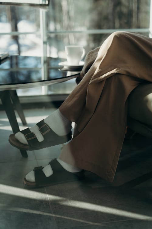 A Person Sitting Beside the Glass Table