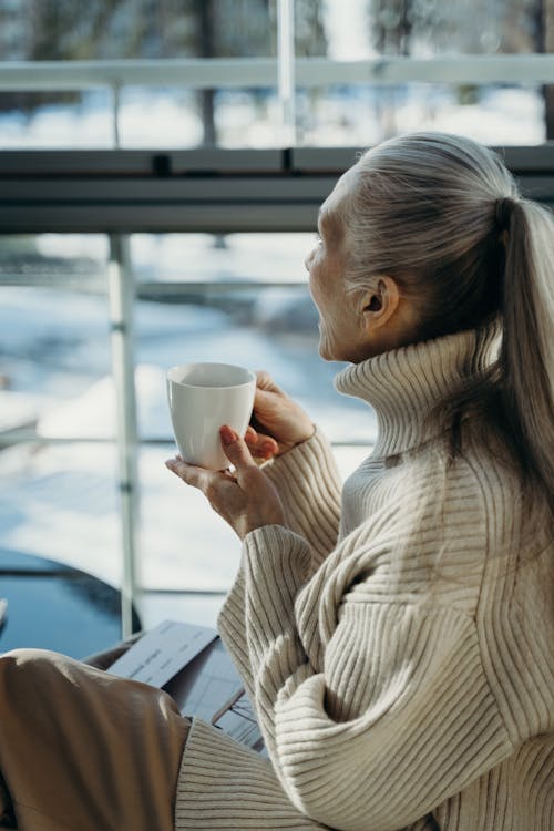 An Elderly Woman Holding a Glass of Coffee