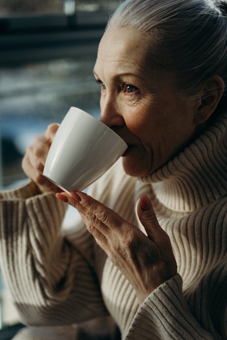 An Elderly Woman Drinking A Coffee