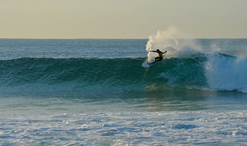 Photo of a Person Surfing at the Beach