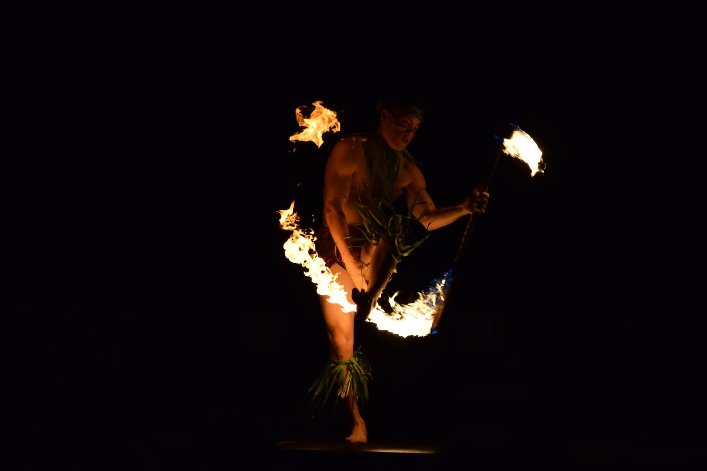 Hula performance under torchlight at a Hawaiian lūʻau