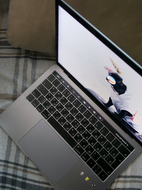 A Silver and Black Laptop on Plaid Textile