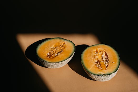 A vibrant close-up of a sliced melon highlighting textures with dramatic light and shadow.