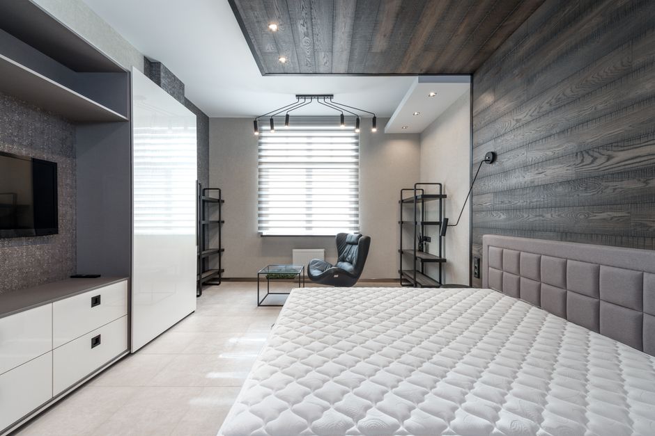 Altbau-Schlafzimmer mit heller, gedämmter Außenwand und ruhiger, schlichter Einrichtung für warme Oberflächen