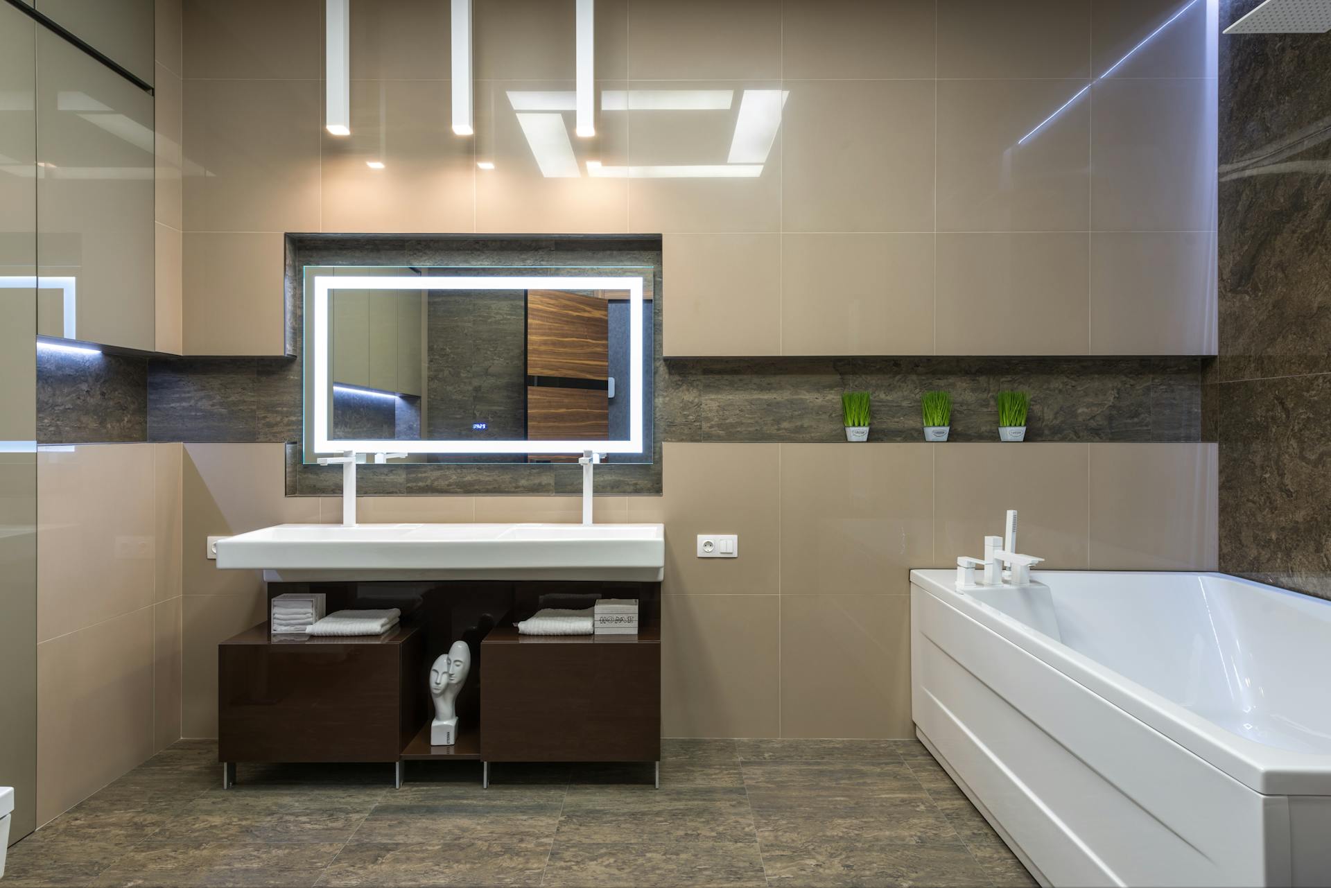 Contemporary bathroom featuring clean lines and elegant decor with a spacious tub and illuminated mirror.