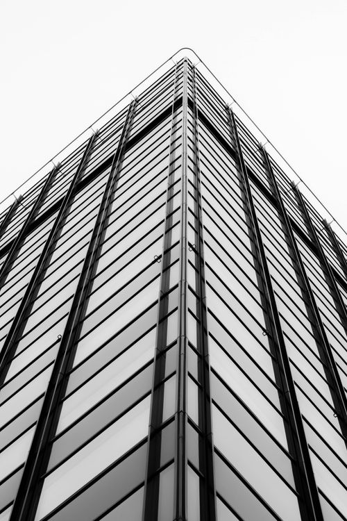 Free Dramatic black and white perspective of a modern skyscraper highlighting architectural design. Stock Photo