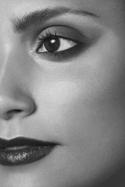 Striking black-and-white close-up of a woman's face showcasing her eye and lips.