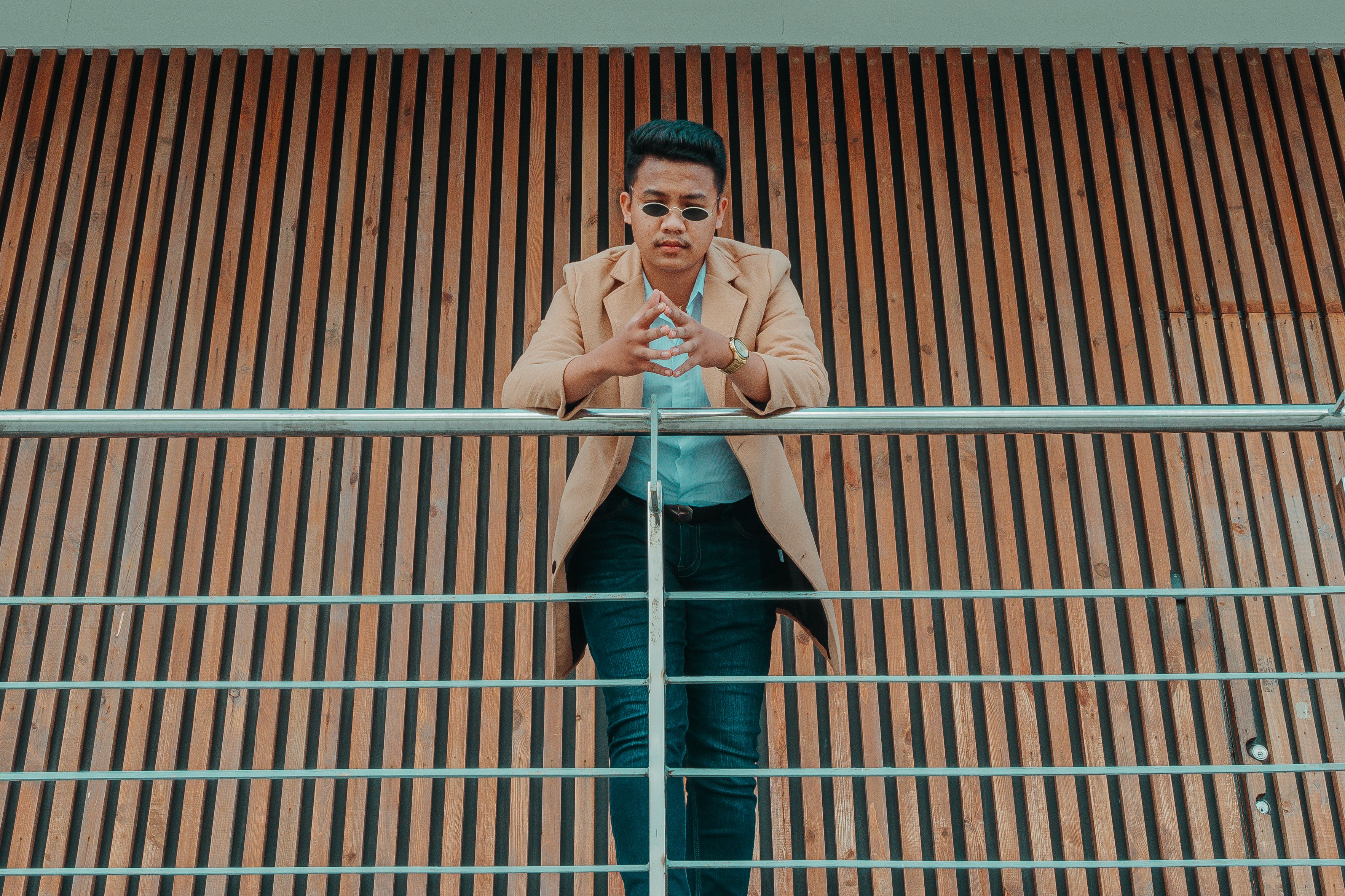 Stylish ethnic man leaning on metal railing · Free Stock Photo