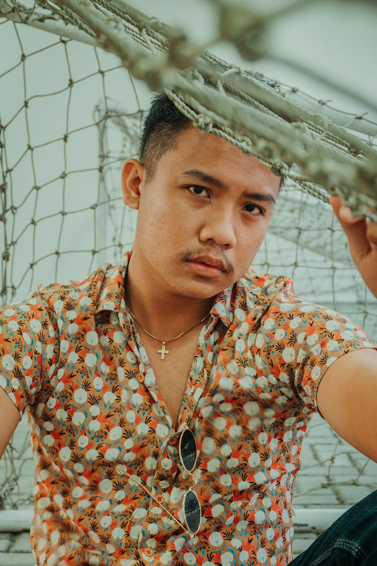 Serious Confident Asian Man Sitting Under Net