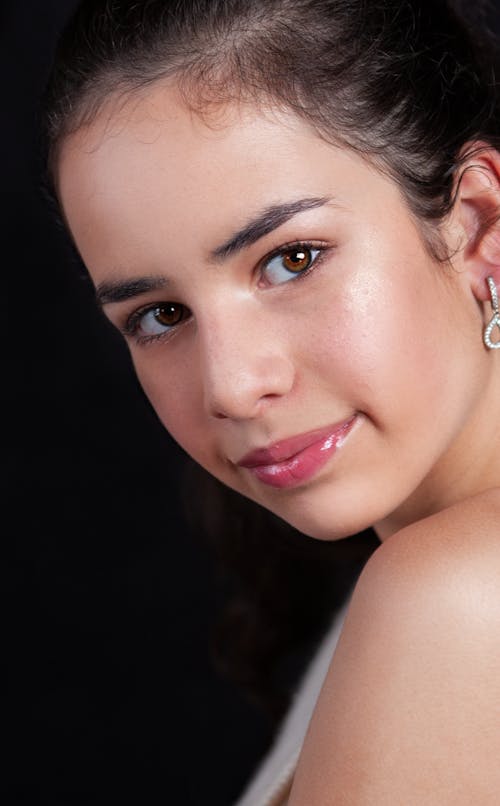 Close-Up Shot of a Pretty Woman Smiling while Looking at Camera