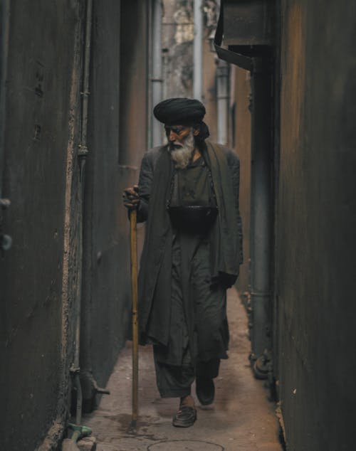 Free Photo of an Old Man Walking in the Alley Stock Photo