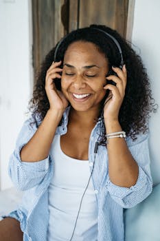 Smiling woman enjoying music with headphones, creating a joyful and relaxed vibe.