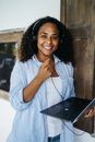 Woman in White and Gray Pinstripe Button Up Shirt Sitting Beside Black Laptop Computer