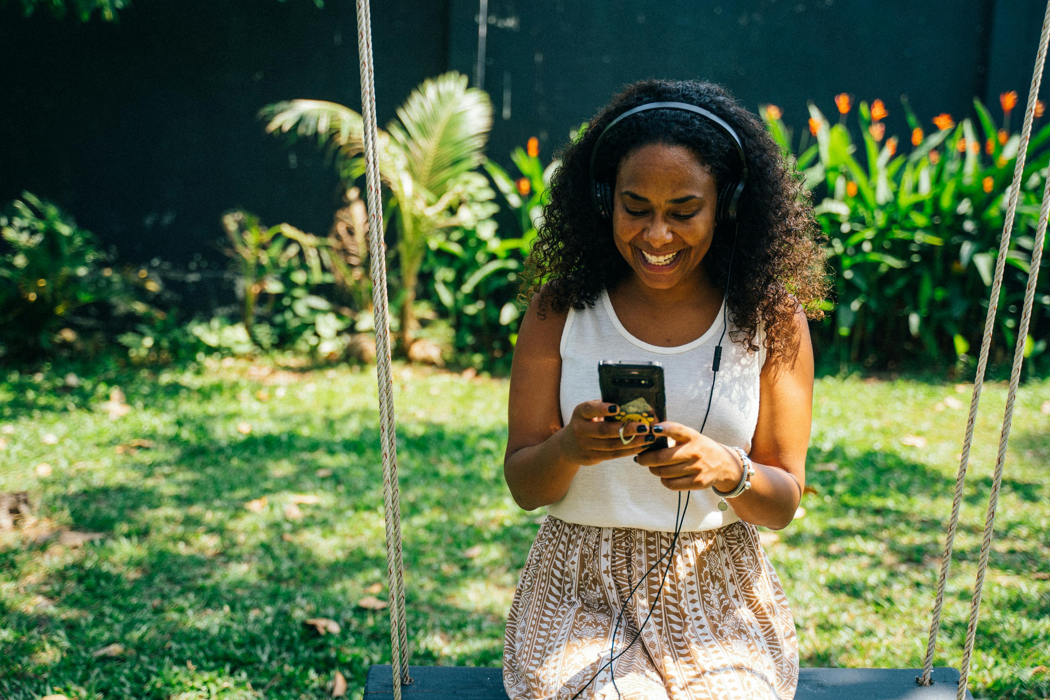 woman in white top holding her phone