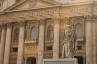 The majestic facade of St. Peter's Basilica in Vatican City featuring a prominent statue.