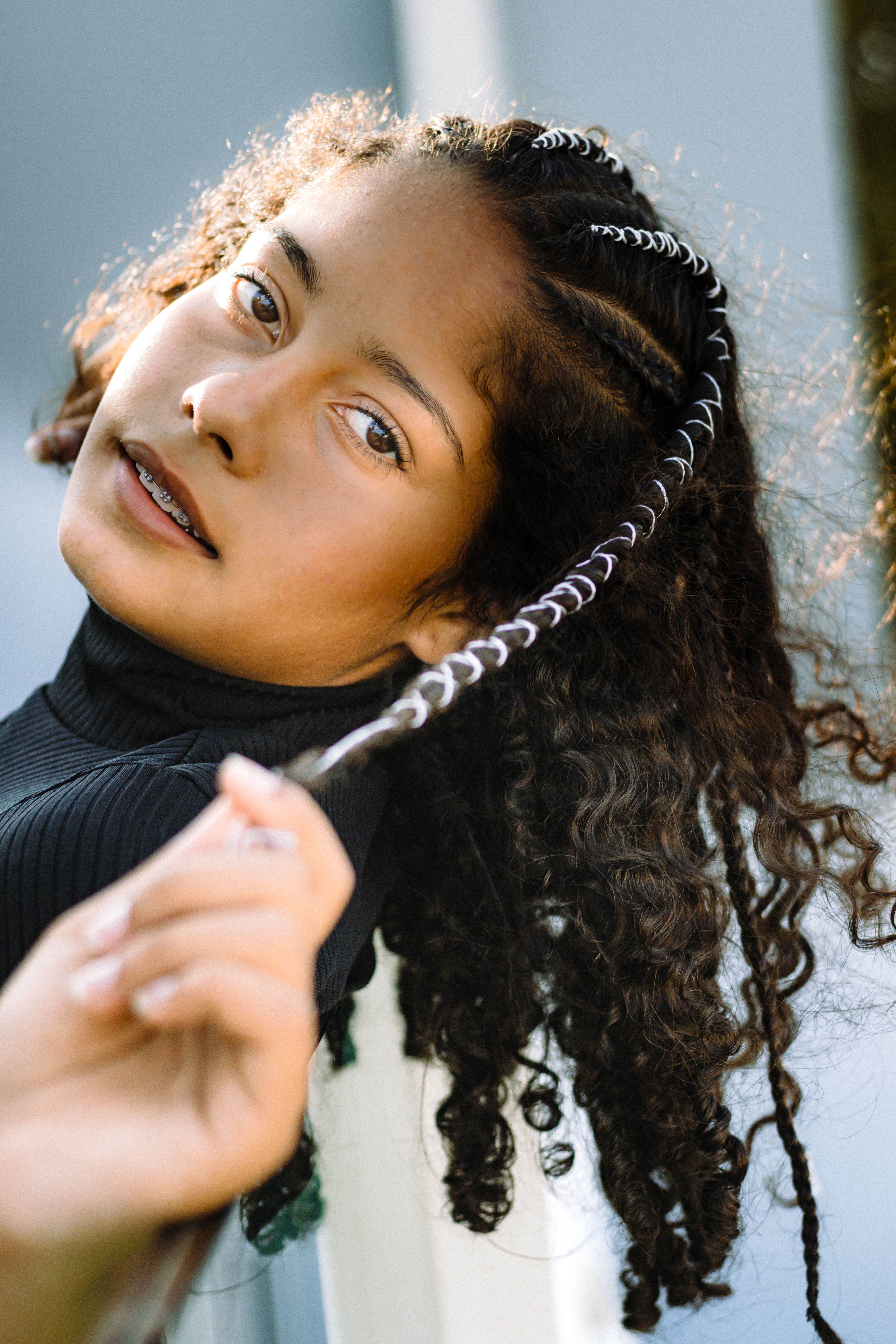 Striking portrait of a woman with braided and curly hair, exuding elegance and style.