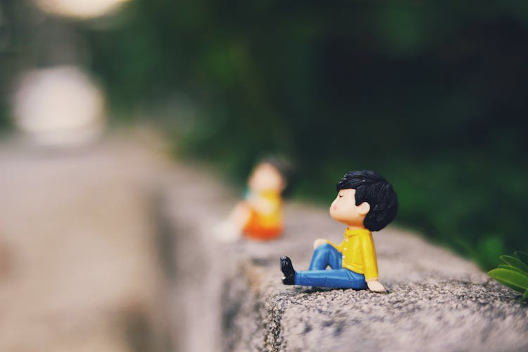 Cute Figurines On Concrete Border