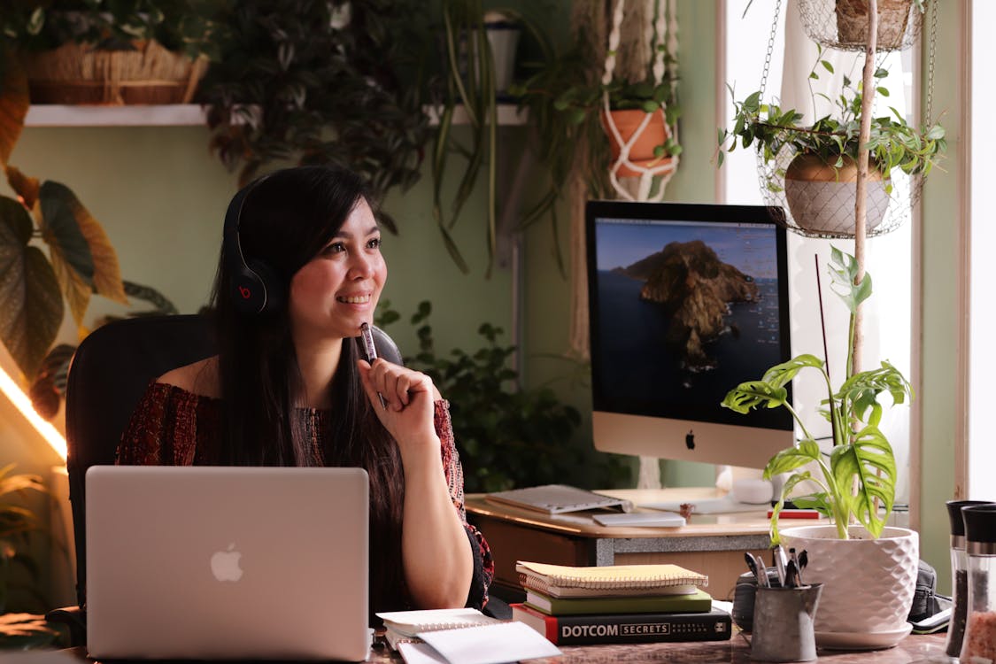 Free Woman Wearing Headphones Holding a Pen Stock Photo