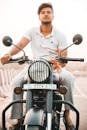 Photo of a Man in a White Shirt Riding a Motorcycle