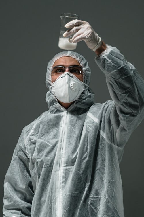 Man in Gray Zip Up Jacket Wearing White Mask