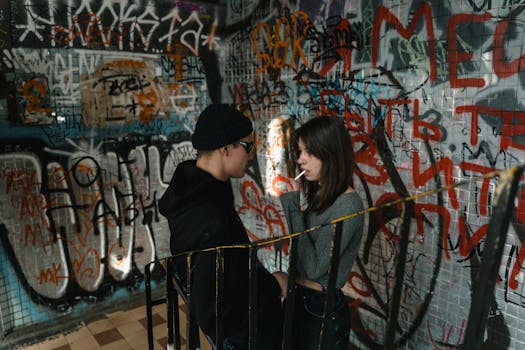 Young adults in a graffiti-covered setting, embodying urban street culture and youthful rebellion.