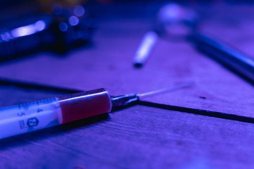Free A close-up of a syringe with a dark and moody tone, symbolizing addiction and treatment. Stock Photo