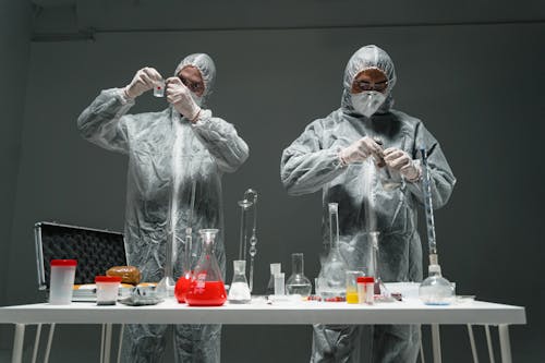 Free Persons Wearing Personal Protective Equipment Testing a Specimen Stock Photo