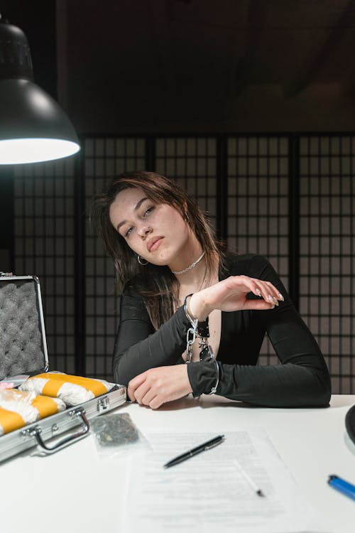 Woman in Black Long Sleeve Shirt Sitting at the Table