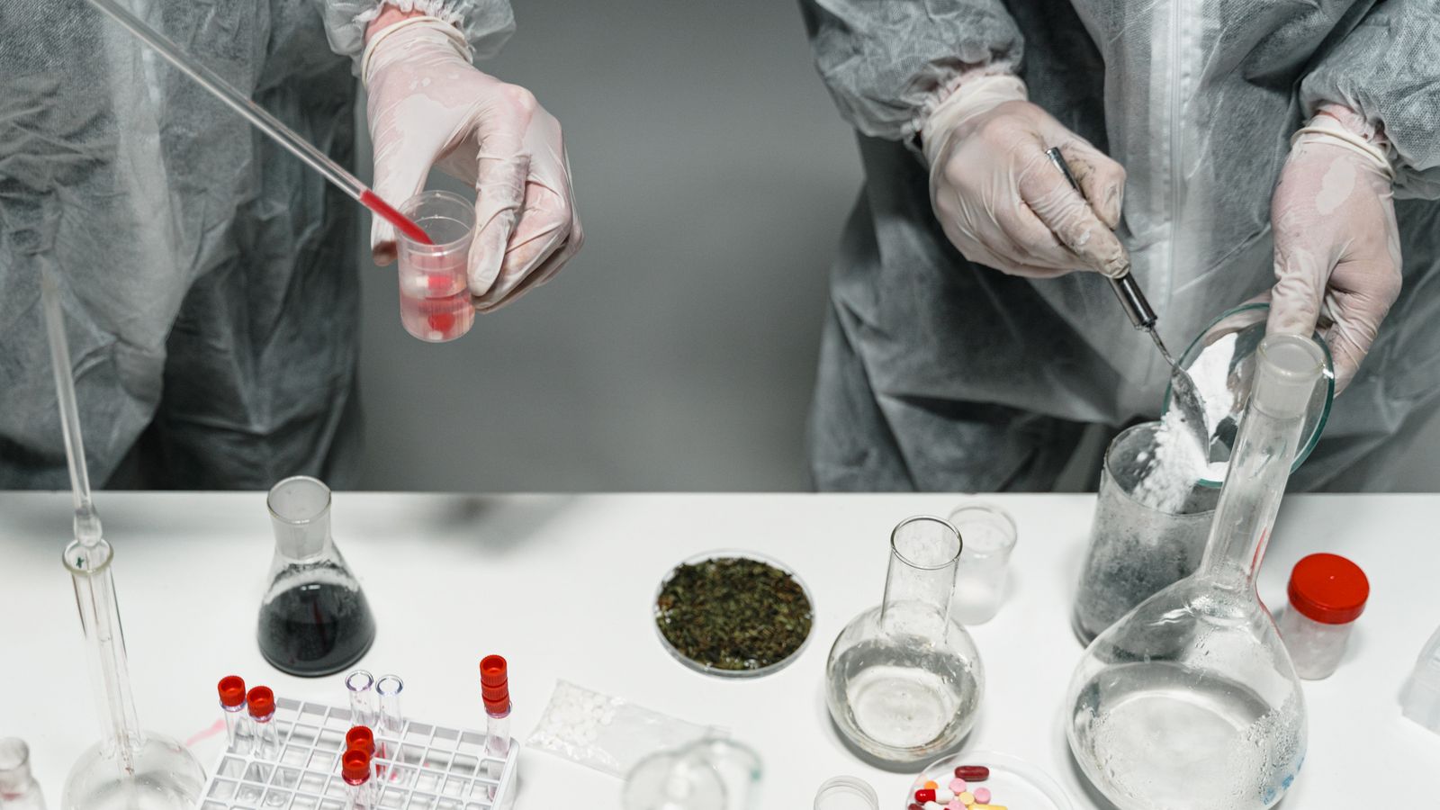 Scientists in protective gear conducting experiments in a modern laboratory setting.