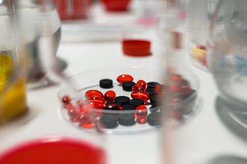 Close Up Shot of Red and Black Tablets on the Table