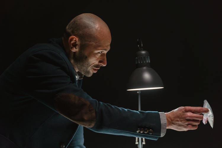 A Law Enforcer Holding The Evidence Inside An Interrogation Room