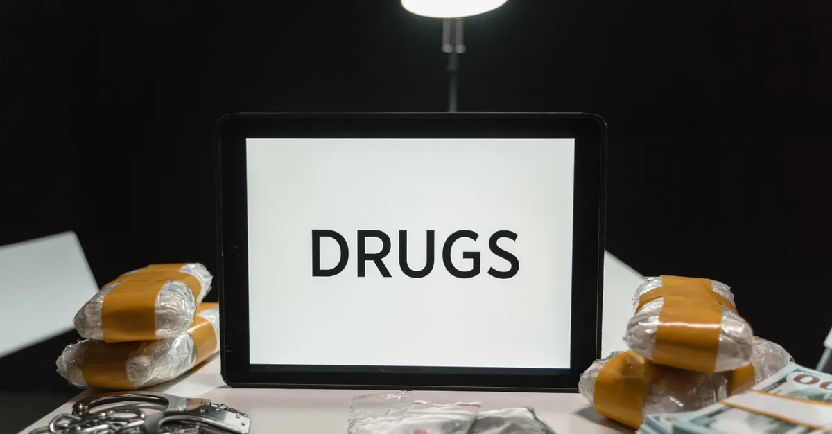 Seized narcotics, currency notes and handcuffs on a desk, depicting an NDPS commercial-quantity bail case