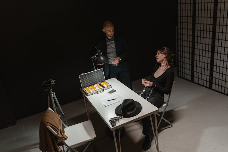 A Woman And A Law Officer Inside The Interrogation Room