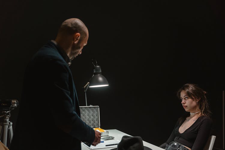 Man In Black Suit Standing In Front Of  Woman Sitting