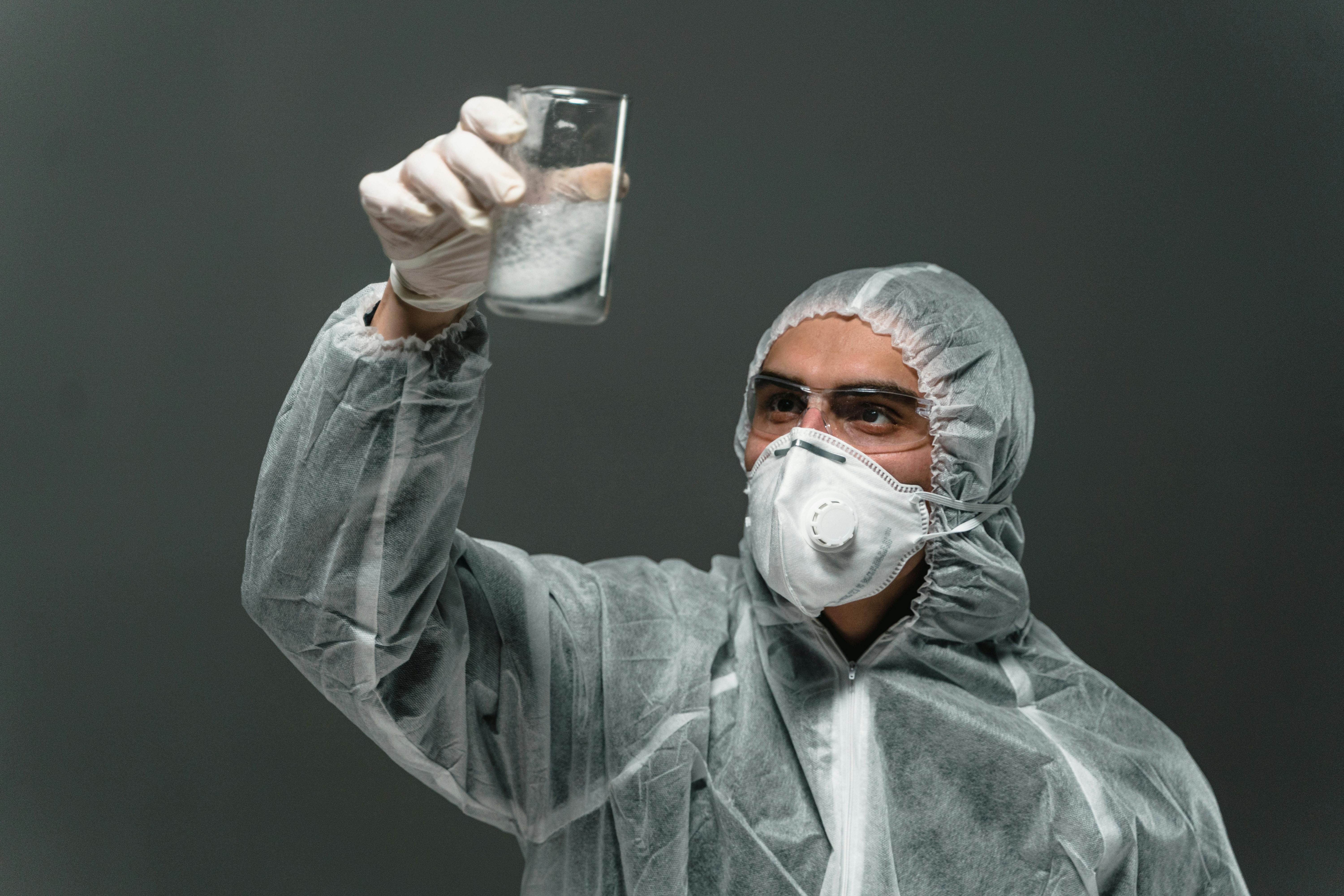 man in gray hoodie drinking from clear drinking glass