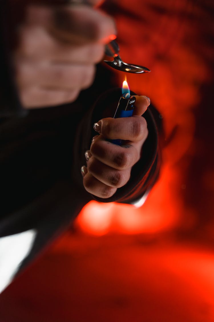 Person Holding A Lighter And Spoon