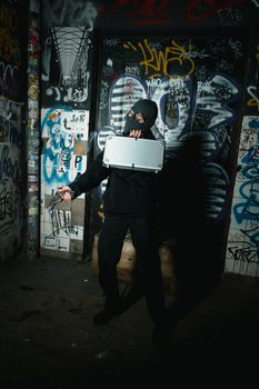 Person in Black Jacket with Mask Holding a Silver Briefcase and Gun