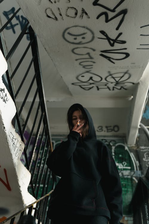 Woman in Black Hoodie Sweater Smoking in the Staircase · Free Stock Photo