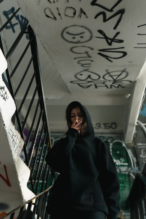 Woman in Black Hoodie Sweater Smoking in the Staircase