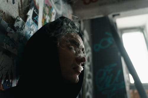 Woman in Black Hijab Looking at Glass Window